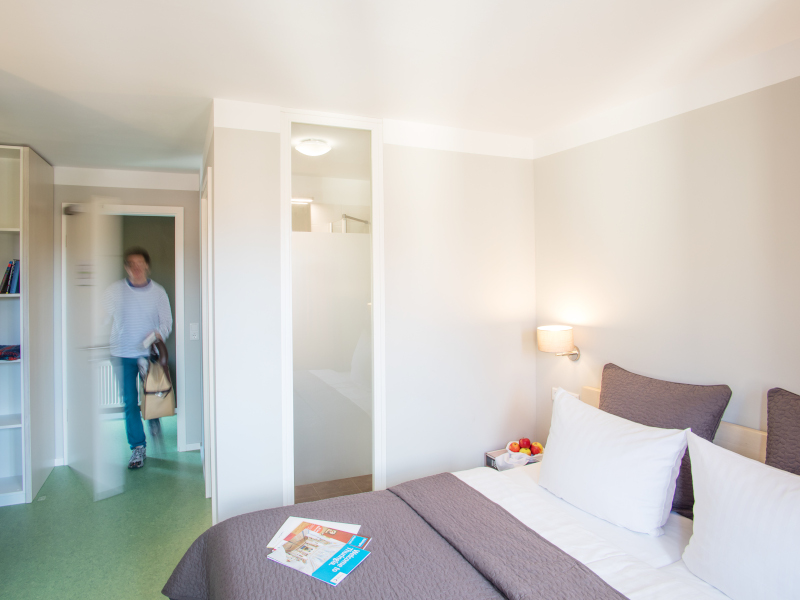 Doppelbett und Eingangsbereich im AMATO Doppelzimmer
