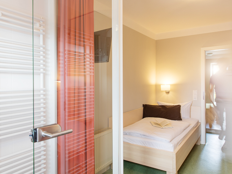 Einzelbett hinter der gläsernen Abtrennung im AMATO Einzelzimmer